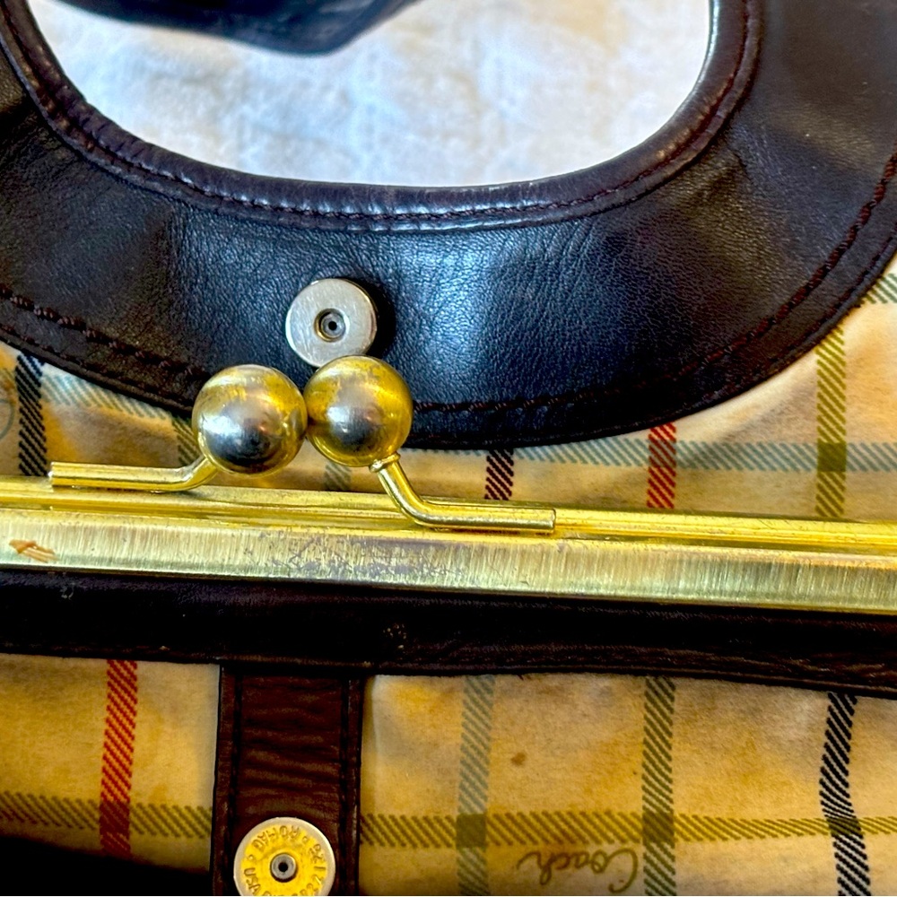 Coach leather bag with plaid interior the needs cleaning .